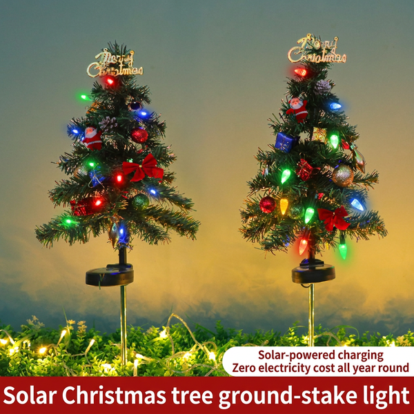 Two solar Christmas tree stake lights glowing with multicolor LED bulbs and Merry Christmas toppers at dusk